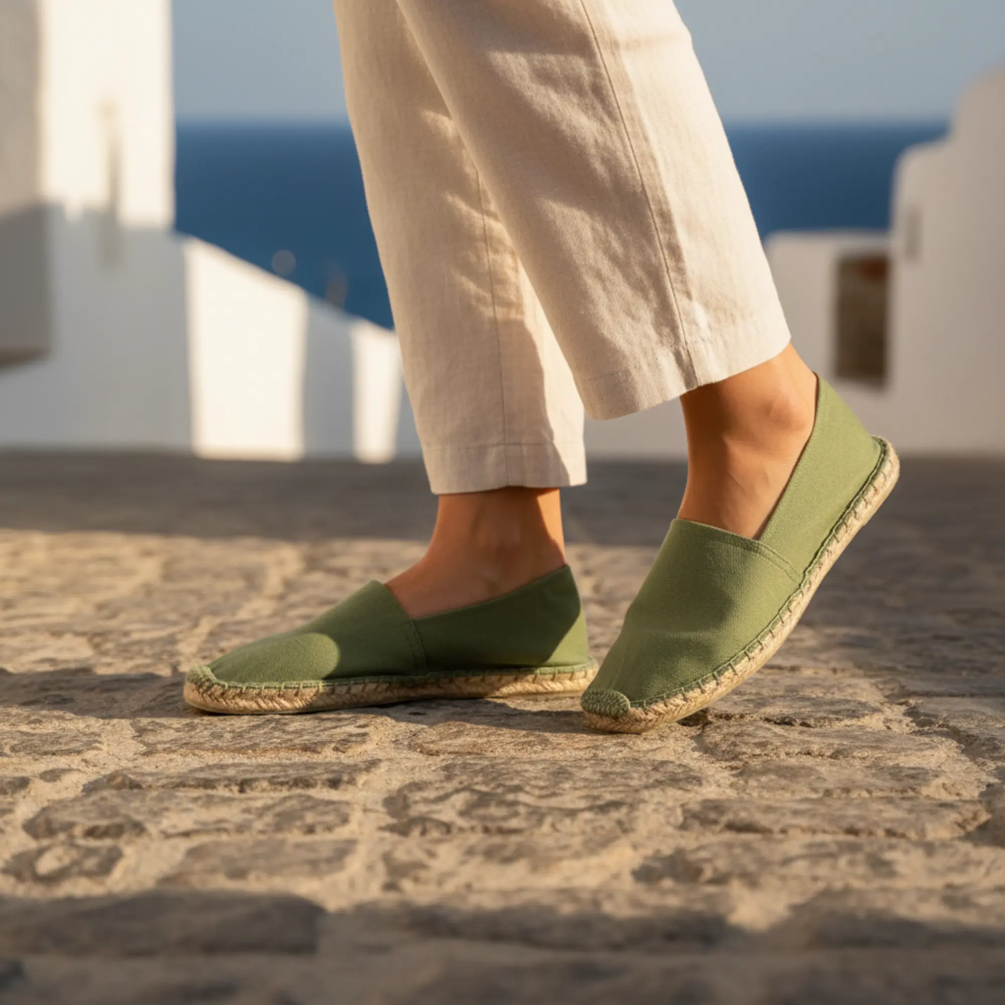 Olivgrüne Espadrilles an einer Person, Steinweg, Sommer.