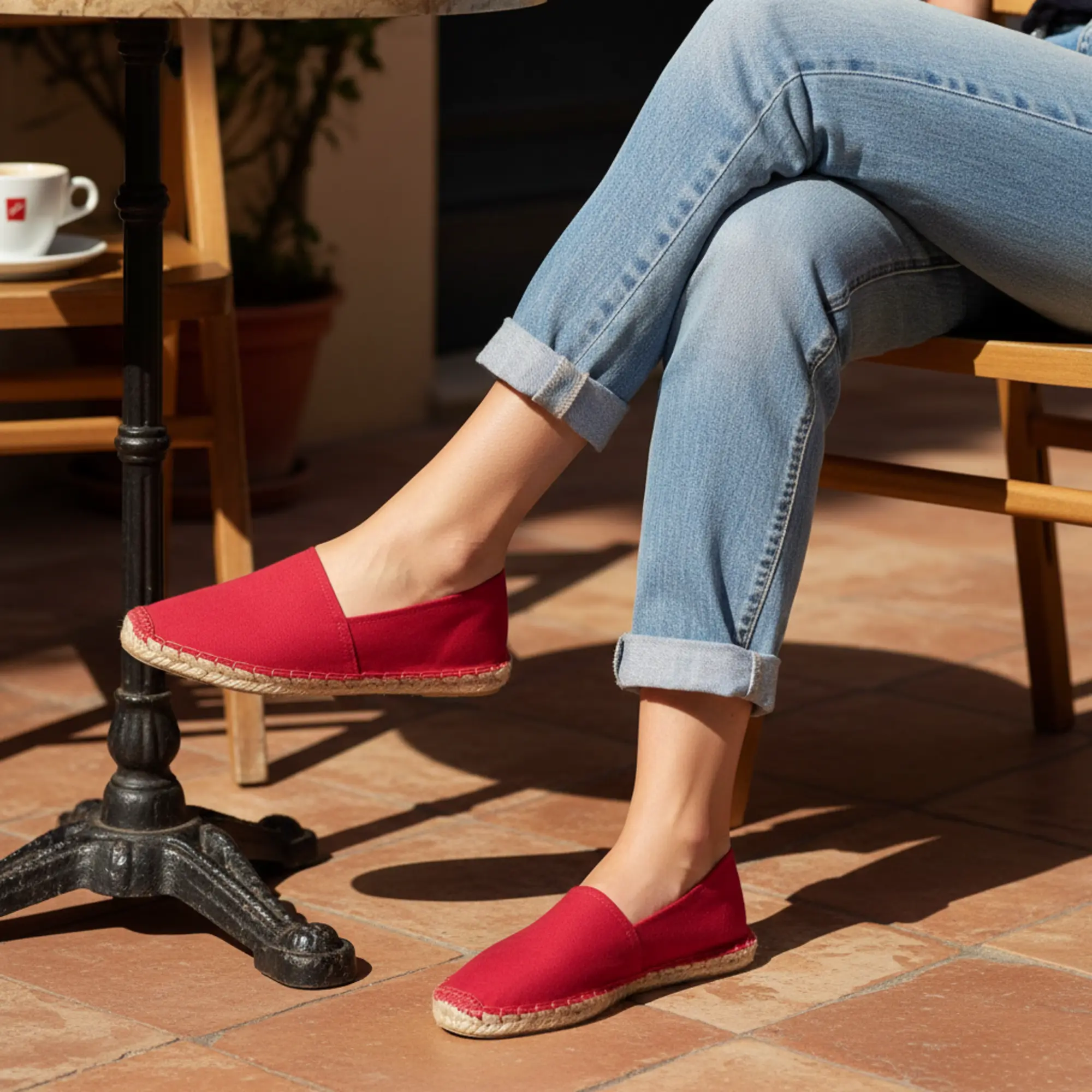 Eine Person trägt im Café rote Espadrilles.
