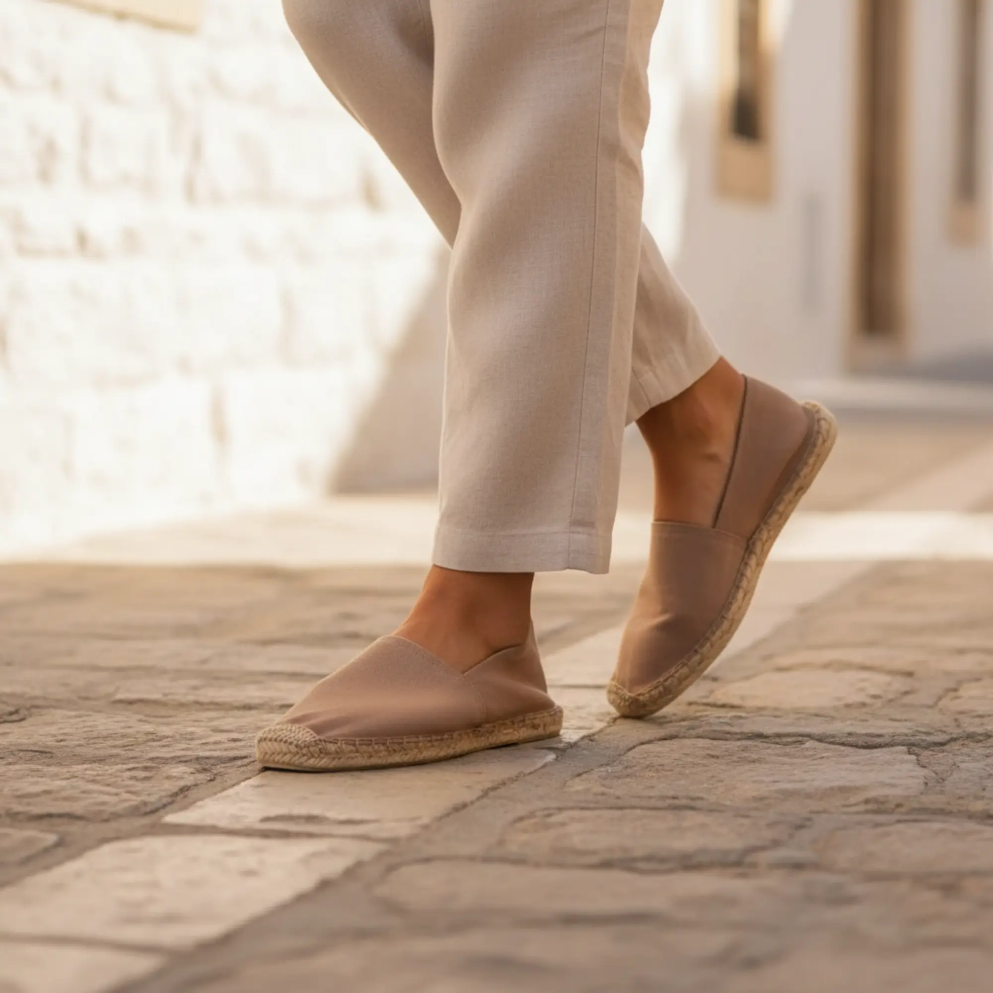 Espadrilles in Café-au-lait-Farbe auf Ziegelstein.