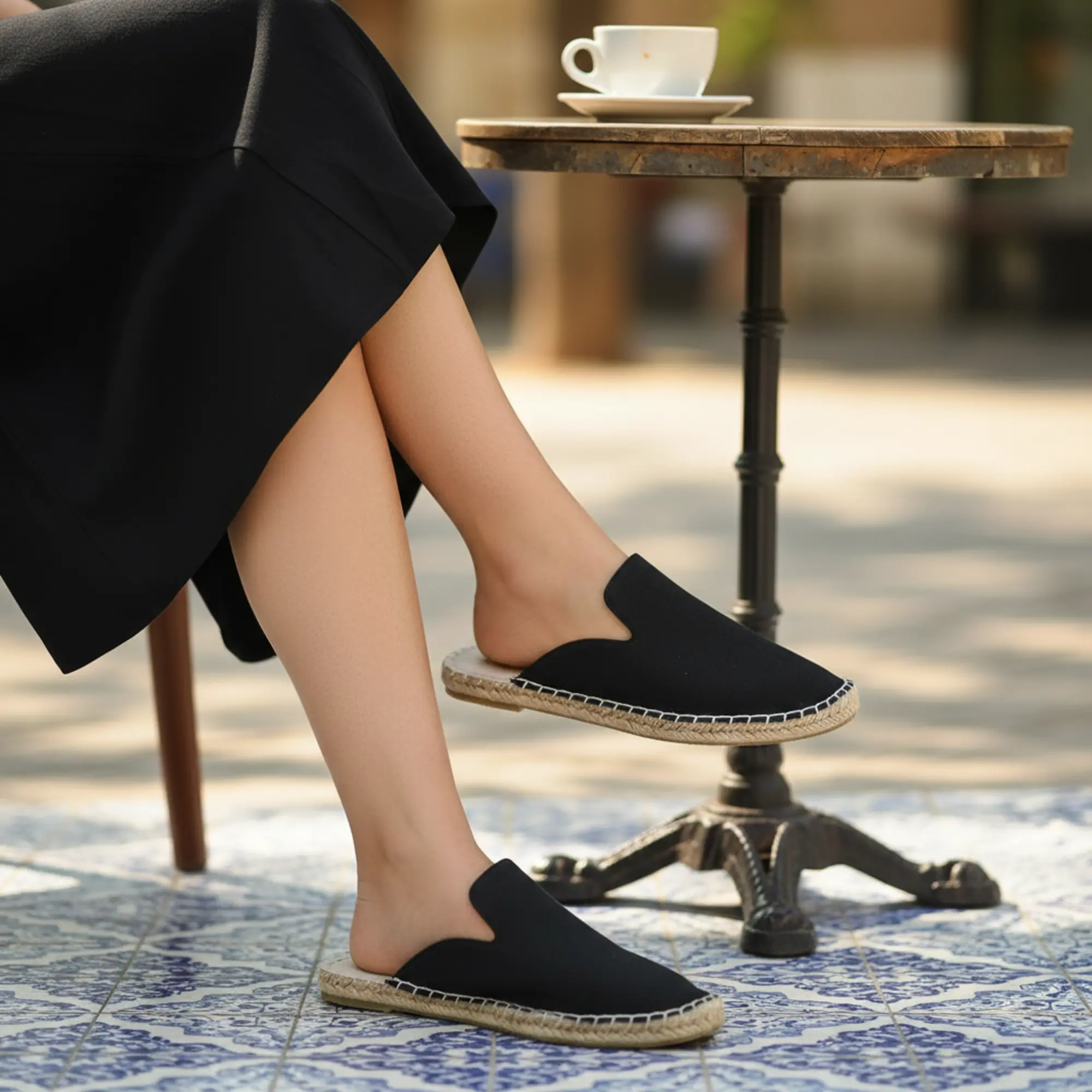 Frau sitzt draußen und trägt marineblaue Espadrilles.
