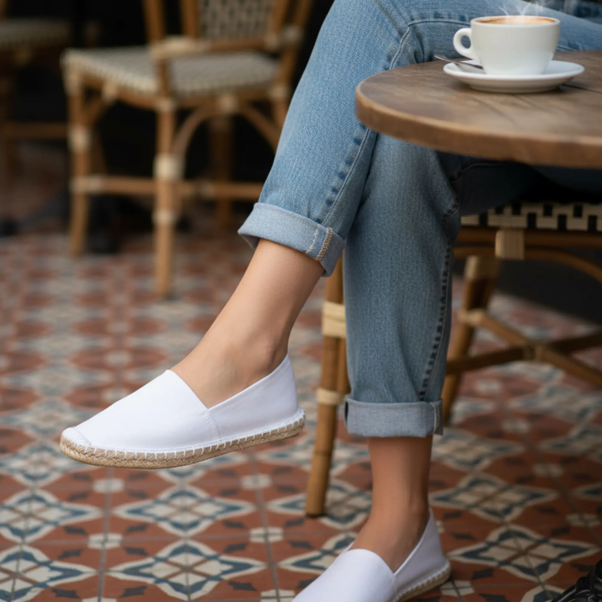 Weiße Espadrilles, blaue Jeans, Café-Tisch, Latte.