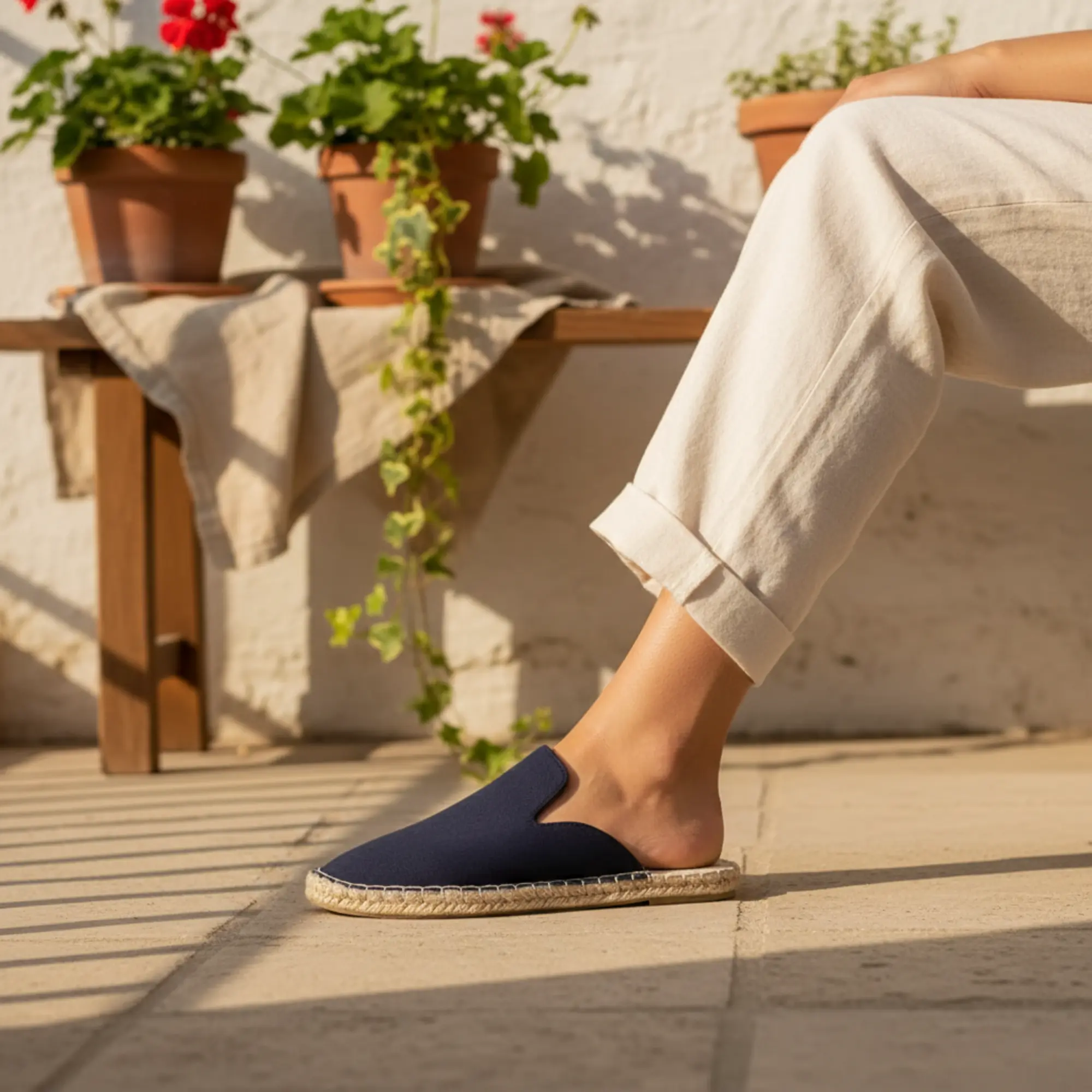 Person, die im Sommer in der Sonne marineblaue Espadrilles trägt.